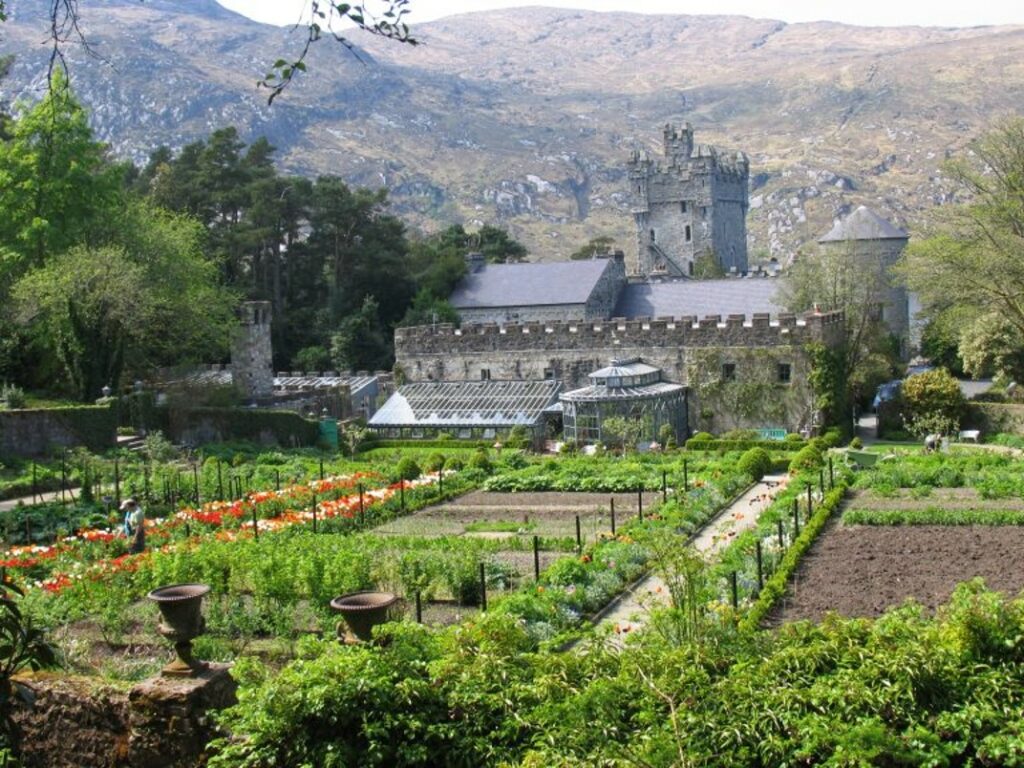 The image shows a view of Glenveagh Castle taken from above the walled vegetable garden.
